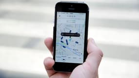 Un possesseur de Smartphone commande un Uber sur l'application française du service de transport, le 17 juin 2015