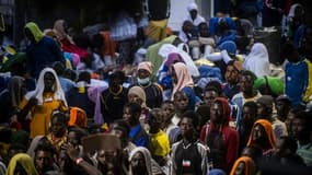 Des migrants attendent devant le centre d'accueil de Lampedusa, le 14 septembre 2023 en Italie.