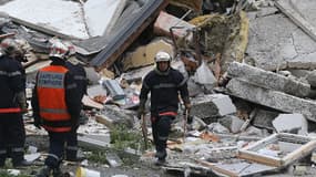 Sapeurs-pompiers dans les décombres de l'immeuble effondré de Reims, dimanche.
