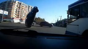 Une voiture russe fait un salto arrière en plein carrefour urbain.