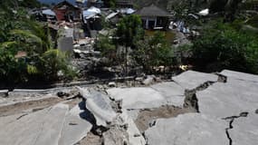 Du béton craquelé et des maisons endommagées, le 6 août 2018 au nord de Lombok en Indonésie, après un séisme de magnitude 6,9.