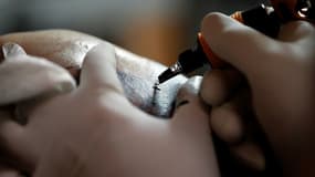 Un tatoueur en action - Image d'illustration 