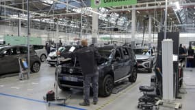 Un employé examine une voiture dans l'usine "ReFactory" de Flins, près de Paris, le 30 novembre 2021