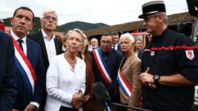 La Première ministre Élisabeth Borne auprès de sapeurs-pompiers à Wintzenheim (Haut-Rhin) le 9 août 2023 après l'incendie dans un gîte qui a fait 11 morts. 