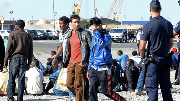 Des policiers surveillent des migrants, à Calais, en août dernier.