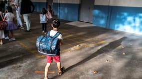 Un élève, cartable sur le dos. 
