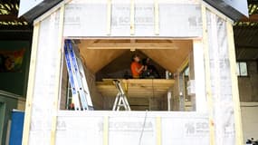 Karine, en apprentissage, travaille sur une "tiny house" construite par des sans-abri, le 28 avril 2022 à Séné, dans le Morbihan