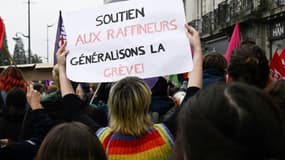 Une manifestante brandit une pancarte avec le slogan "Soutien aux raffineurs, généralisons la grève !" lors de la journée de mobilisation nationale du 18 octobre 2022, à Rennes