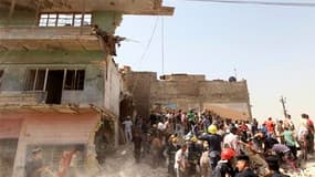 Secouristes et habitants sur les lieux d'une explosion dans le centre de Bagdad. Des explosions coordonnées ont détruit sept bâtiments dans plusieurs quartiers de la capitale irakienne, faisant 35 morts et 140 blessés. /Photo prise le 6 avril 2010/REUTERS
