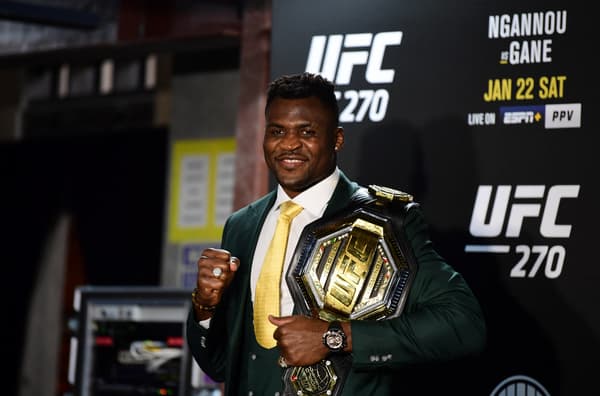 Francis Ngannou tout sourire avec sa ceinture de champion des lourds après sa victoire sur Ciryl Gane à l'UFC 270 en janvier 2022