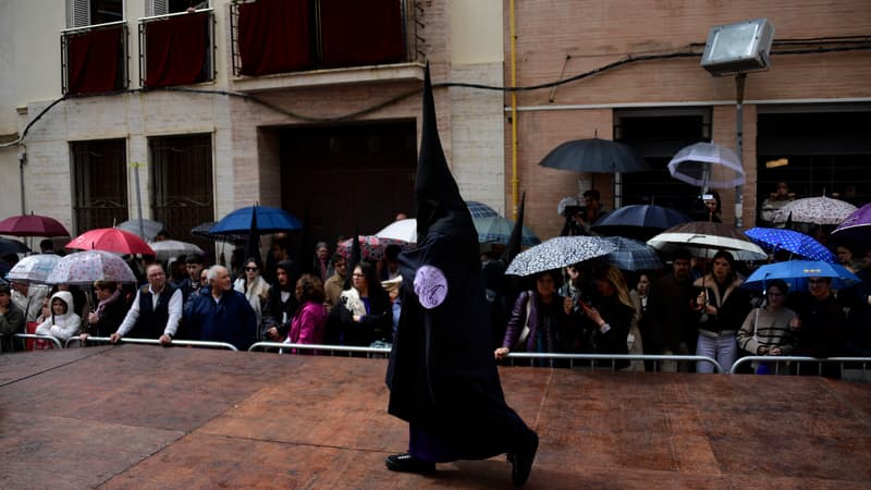 Un pénitent de la confrérie 'San Bernardo' s'éloigne de l'église après que la procession ait été suspendue à cause de la pluie pendant la Semaine sainte à Séville le 27 mars 2024.
