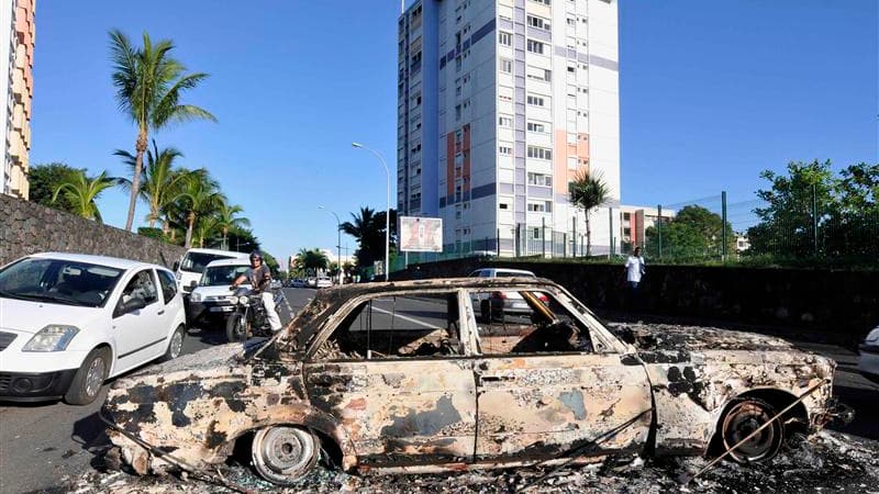 Un véhicule calciné dans le quartier du Chaudron, à Saint-Denis, à La Réunion, où des violences ont éclaté dans la nuit de mardi à mercredi en marge d'une manifestation de routiers qui protestaient contre les prix élevés des carburants et la vie chère. /P