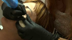 Une opération de maquillage permanent dans un salon de tatouage 