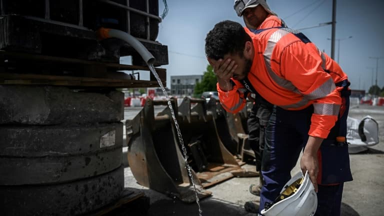 Des ouvriers sur un chantier se rafraîchissent avec de l'eau, le 14 juin 2022 à Mérignac, près de Bordeaux