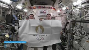 Thomas Pesquet et Aki Hoshide brandissent le drapeau Paris 2024 dans l'ISS. 