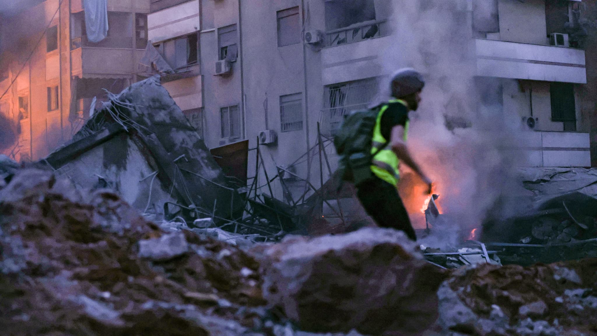 Un secouriste court au milieu des décombres d'un immeuble détruit par une frappe aérienne israélienne dans le quartier de Haret Hreik, dans la banlieue sud de Beyrouth, le 27 septembre 2024.