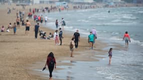 Des promeneurs et quelques baigneurs sur la plage de Valence, le 9 mai 2021 en Espagne