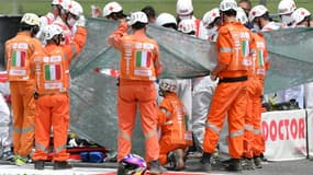 Des secouristes prodiguent les premiers soins au pilote suisse Jason Dupasquier, victime d'une lourde chute impliquant trois motos, lors des qualifications du Grand Prix d'Italie en catégorie Moto3, le 29 mai 2021 sur le circuit de Mugello