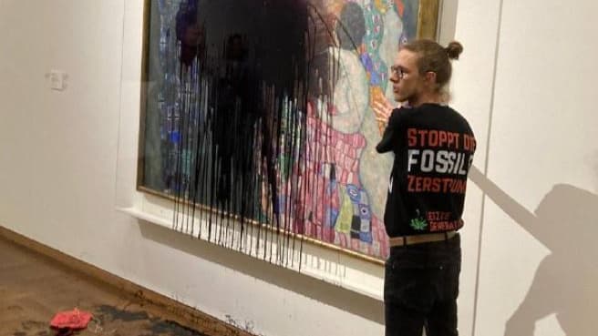 Un militant écologique collé à un tableau de Klimt qu'il vient d'asperger de liquide noir dans un musée à Vienne, le 15 novembre 2022.