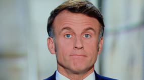 Le président français Emmanuel Macron est vu sur un écran alors qu'il prononce son discours télévisé du Nouvel An à la nation depuis le palais de l'Élysée, à Paris, le 31 décembre 2024.