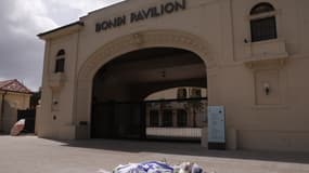 Des fleurs et un drapeau israélien sont déposés en mémoire des victimes d'une fusillade à Bondi Beach, devant le Bondi Pavilion à Sydney (Australie), le 15 décembre 2025.