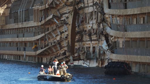 Membres de l'opération de sauvetage devant l'épave du Costa Concordia après son redressement, le 18 septembre.