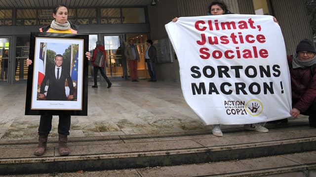 Un militant écologiste retire le portrait d'Emmanuel Macron au sein de la mairie de Saint-Sébastien-sur-Loire, le 4 mars 2019.
