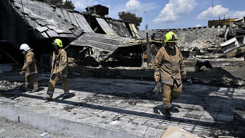 ILLUSTRATION - Des sauveteurs marchent dans le centre commercial Amstor détruit à Krementchouk, le 29 juin 2022, deux jours après qu'il a été touché par une frappe de missile russe selon les autorités ukrainiennes.