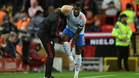 Paul Pogba échange avec un des entraîneurs de Manchester United avant sa sortie sur blessure contre Liverpool à Anfield, le 19 avril 2022 