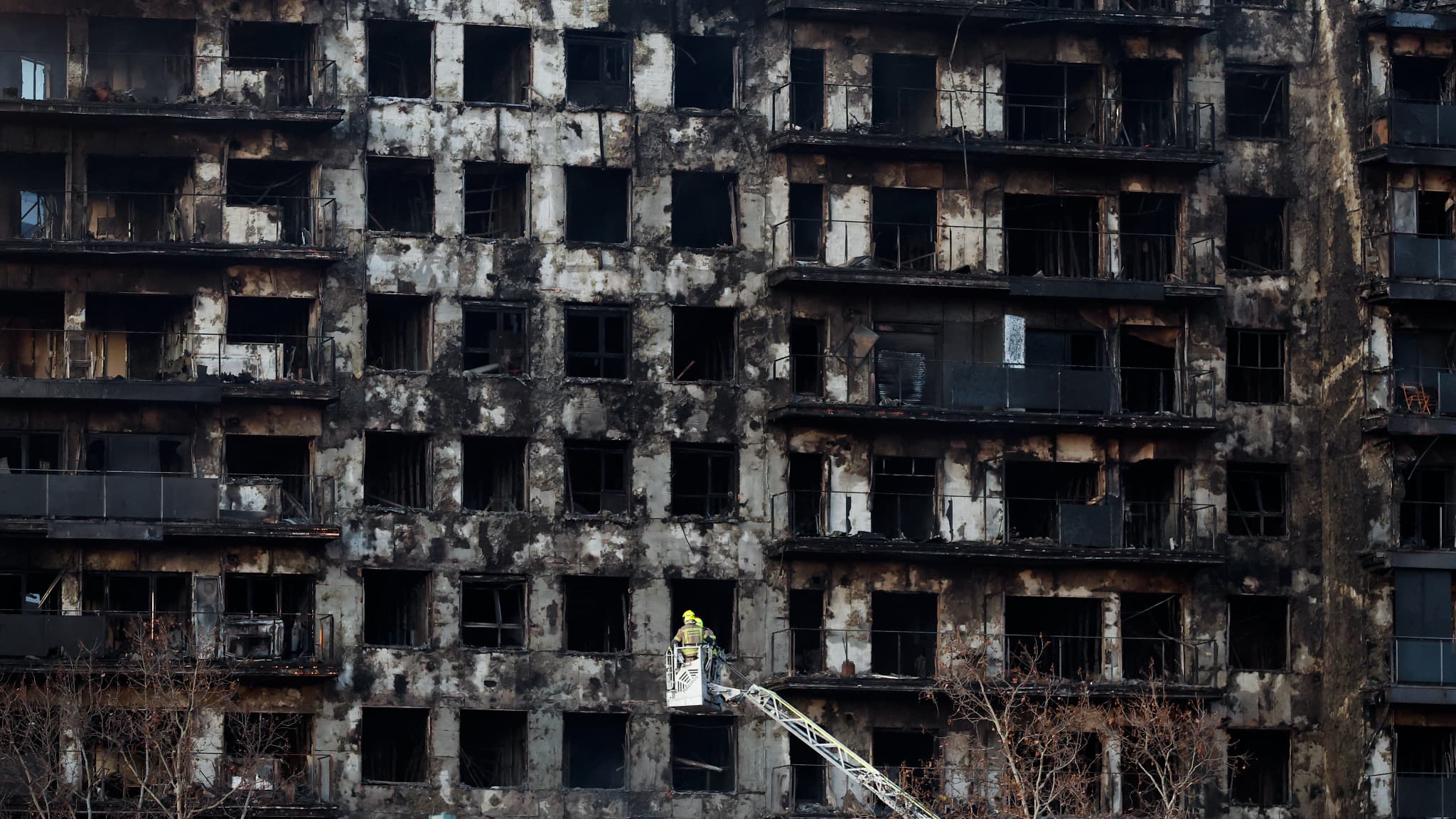 Des pompiers inspectent les conséquences d'un gigantesque incendie qui a ravagé hier un immeuble résidentiel de plusieurs étages, tuant au moins quatre personnes, à Valence, le 23 février 2024. Des pompiers inspectent les conséquences d'un gigantesque incendie qui a ravagé hier un immeuble résidentiel de plusieurs étages, tuant au moins quatre personnes, à Valence, le 23 février 2024.
