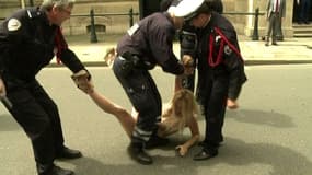 Une Femen maîtrisée par la police devant l'Elysée, mercredi.