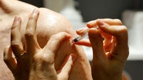 Un pharmacien vaccine un patient contre la grippe à Paris le 13 octobre 2020