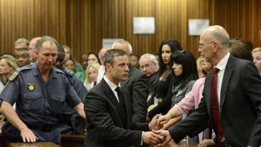 Oscar Pistorius serre la main de son oncle Arnold Pistorius avant d'être emmené en prison à l'issue de son procès le 21 octobre 2014 à Pretoria