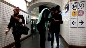 Des voyageurs du métro parisien et un agent de la RATP dans les couloirs de la station Châtelet, le 10 décembre 2019.
