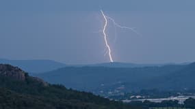 Un éclair frappe une colline au loin lors d'un orage près du Muy, dans le sud de la France, le 12 juin 2023.