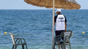 Un membre de la police du tourisme tunisienne surveille les vacanciers lors d'un hommage aux victimes de Sousse