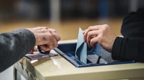 Une personne dépose un bulletin de vote lors des élections parlementaires européennes, dans un bureau de vote de la mairie de Trappes, le 26 mai 2019