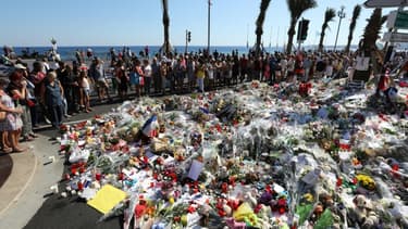 Des personnes déposent des fleurs et des messages à la mémoire des victimes, le 17 juillet 2016 à Nice, trois jours après un attentat qui a fait 86 morts le 14 juillet sur la Promenade des Anglais