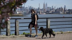 Une femme promenant son chien en portant un masque à Jersey City, près de New York. 