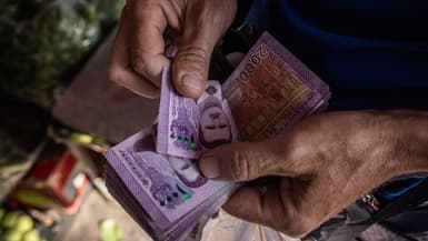Des billets syriens de 2.000 livres à l'effigie de l'ancien président syrien Bachar al-Assad sont comptés alors que les gens font leurs achats dans un marché le 17 juin 2025 à Damas, en Syrie.