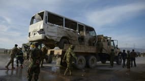 Des soldats afghans se tiennent près d'un bus contre lequel s'est jeté un kamikaze, tuant trois soldats, le 8 février 2016 à Dehdadi, dans l'agglomération de Mazar, en Afghanistan