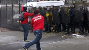 Un manifestant jette un projectile sur les forces de l'ordre, mardi 12 février, devant le siège de Goodyear France, à Rueil-Malmaison dans les Hauts-de-Seine.