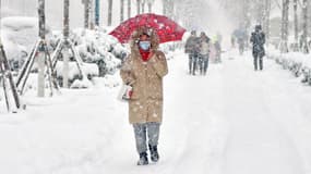 Des passants marchent le long d'un chemin enneigé à Yantai, en Chine, le 20 décembre 2023.