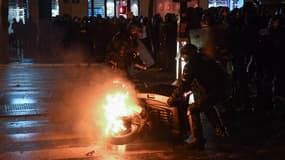 Des forces de l'ordre déplacent une carcasse de scooter enflammée sur la place de la République à Paris, le 26 janvier 2019. 