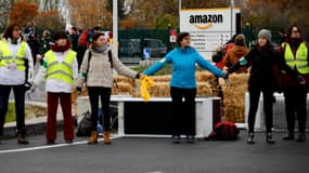 Entre 50 et 100 militants des groupes ANV-COP21 et Amis de la Terre ont installé des bottes de pailles et formé des barrages humains devant le centre de Brétigny-sur-Orge (Essonne) d'Amazon