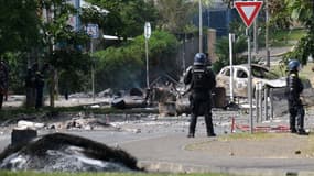 Des gendarmes français gardent l'entrée du quartier de la Vallée-du-Tir, à Nouméa, le 14 mai 2024, lors de manifestations liées à un débat sur un projet de loi constitutionnelle visant à élargir le corps électoral pour les prochaines élections du territoire français d'outre-mer de Nouvelle-Calédonie.