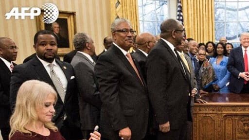 La conseillère du président américain Donald Trump, Kellyanne Conway (g), agenouillée sur un sofa pour prendre une photo du président avec des dirigeants de lycées et d'universités historiquement noirs, le 27 février 2017 dans le Bureau ...