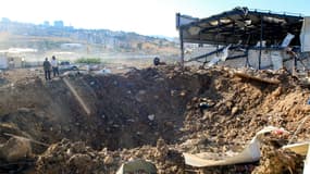 Des personnes se tiennent près d'un cratère d'impact sur le site d'une frappe aérienne israélienne à Jiyeh, le long de l'autoroute reliant Beyrouth à la ville méridionale de Sidon, le 25 septembre 2024. (Photo d'illustration)