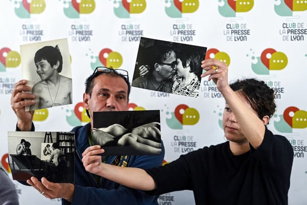 La victime Luc Gemet (à gauche) et sa fille Jasmine (à droite) montrent des photographies en noir et blanc du père Ribes avec Luc Gemet enfant, lors de la première conférence de presse du collectif des victimes du père Ribes, prêtre décédé en 1994 connu pour ses talents artistiques, à Lyon, dans l'est de la France, le 6 mai 2022.
