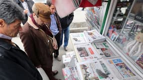 Des Iraniens regardent la une des journaux dimanche à Téhéran, annonçant l'accord sur le nucléaire.